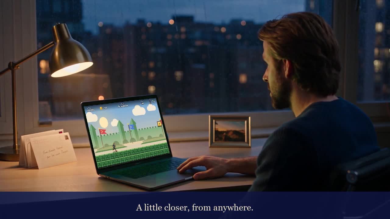 Fictional recipient viewing his personal game on a laptop beside a handwritten envelope